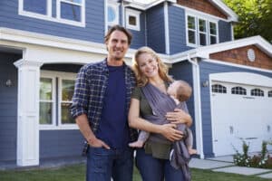 couple standing in front of their house